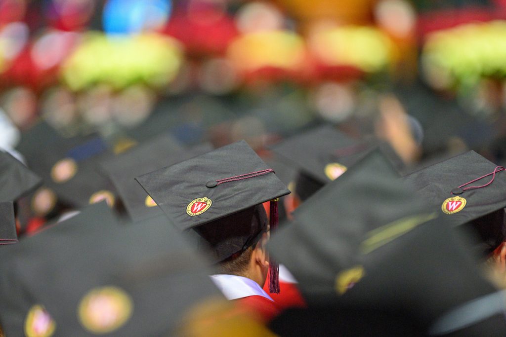 Row of graduate wearing mortarboard caps