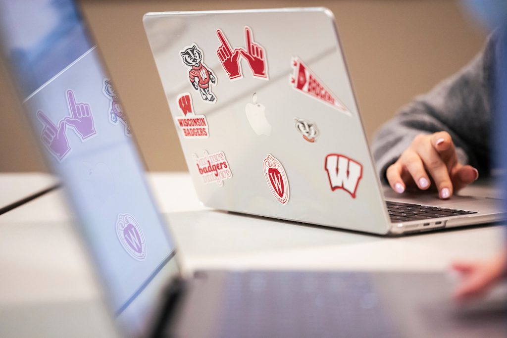 Student works on laptop with UW decals
